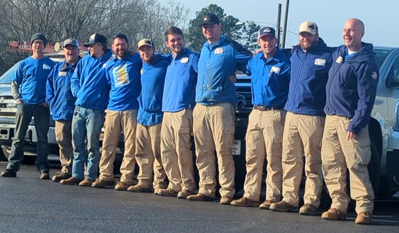 Anytime Heating Cooling Repair Team in Connelly Springs NC posing for a photo outdoors with work vehicles in the background.