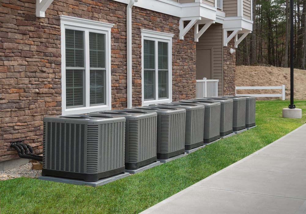 Row of air conditioning units outside townhomes