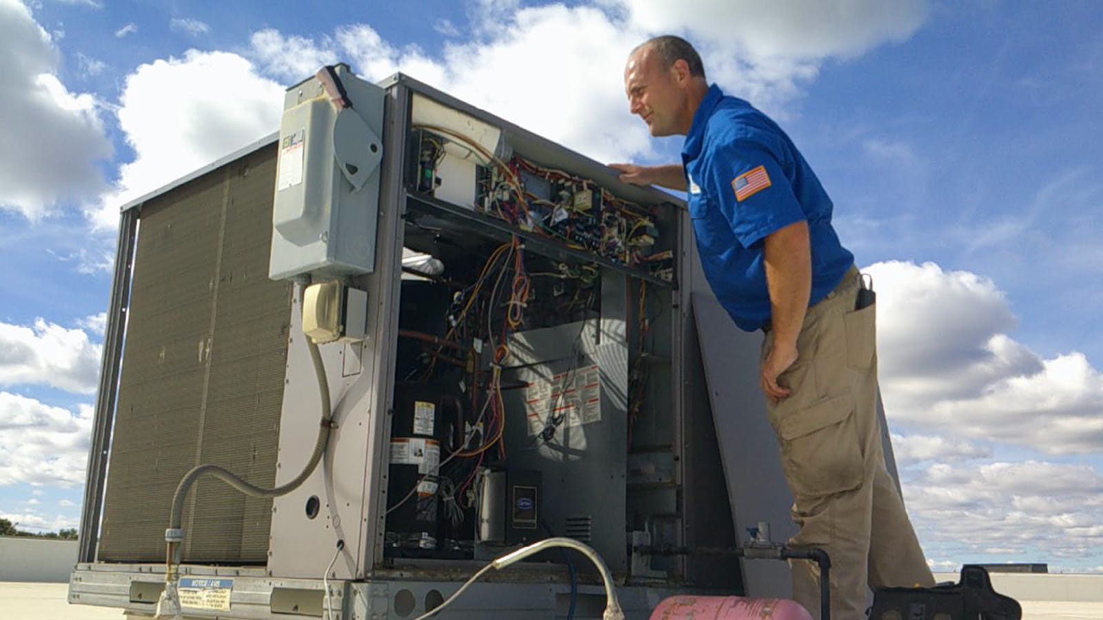 HVAC contractor inspecting the internal components of an industrial air conditioning unit in a commercial space in Hickory, NC.
