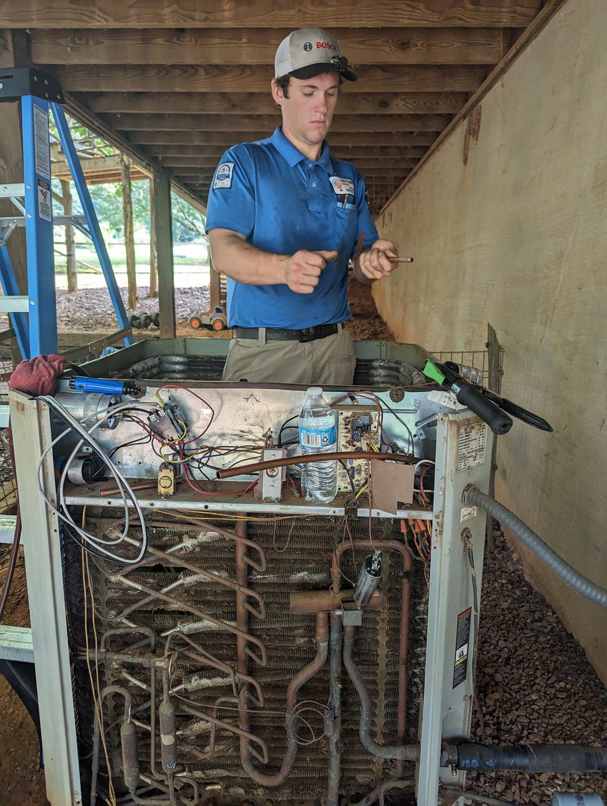 A technician understanding HVAC system components while repairing an air conditioner unit.
